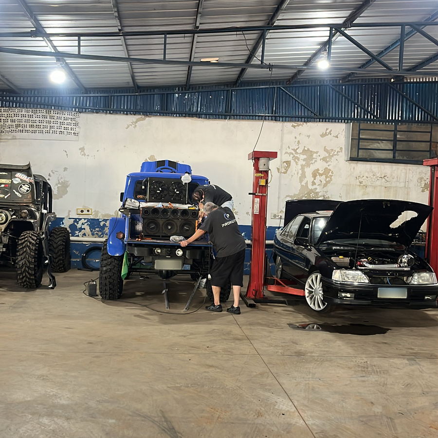 Mecânico da ProAuto trabalhando no motor de um Jeep 4x4 azul dentro da oficina em Ijuí