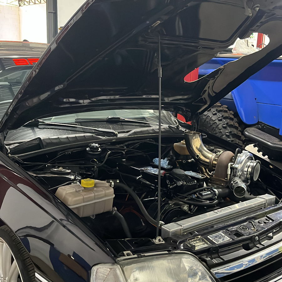 Motor turbinado de Chevrolet Omega com o capô aberto durante revisão na Mecânica ProAuto