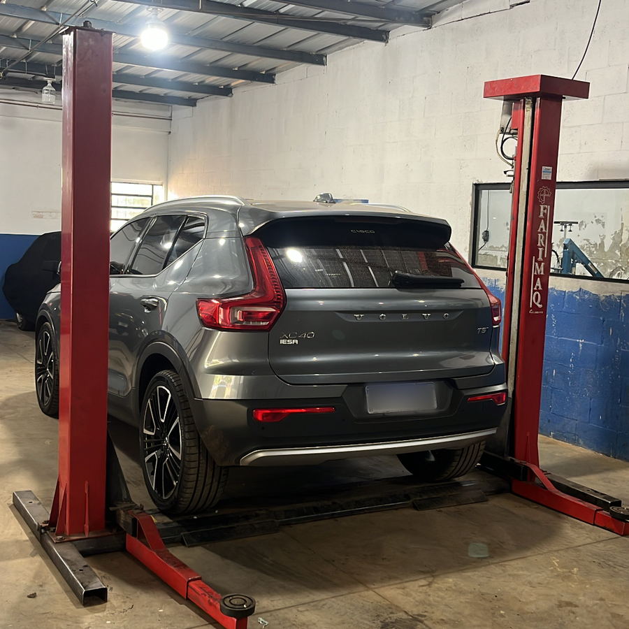 Volvo XC40 cinza suspenso no elevador para revisão na oficina da Mecânica ProAuto